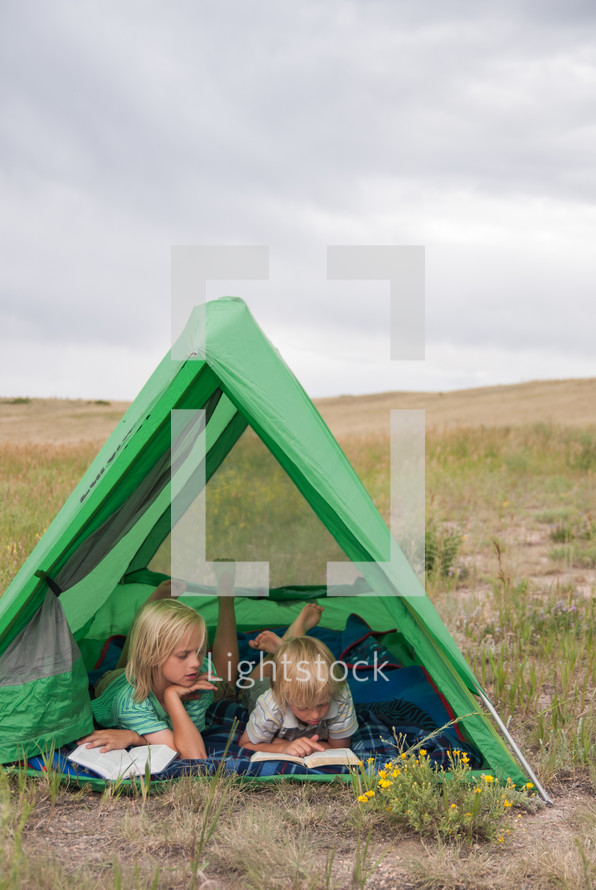 children reading Bibles in a tent