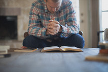 man praying over a Bible 