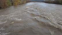 Large river flooding, water flowing at high speed