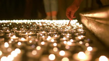 lighting prayer candles in a church 