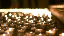 lighting prayer candles in a church at night 