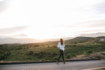 a woman walking on a mountain road 
