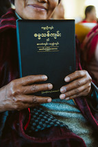 a woman holding a Bible in Myanmar 