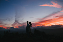 a couple at sunset against a fiery sky 