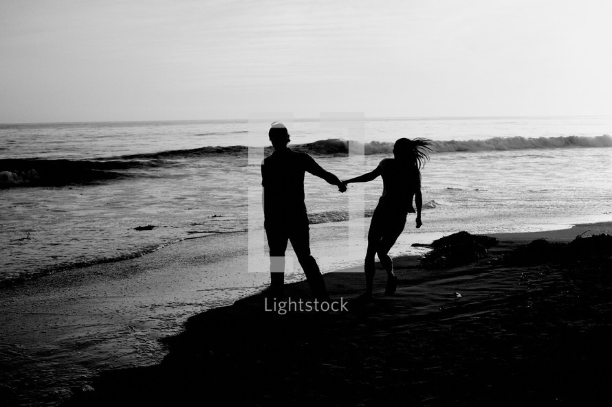 couple walking together holding hands on a beach