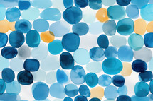 Abstract watercolor pattern featuring soft, overlapping circles in various shades of blue, teal, and hints of yellow. The design evokes a calm, coastal vibe with a modern touch.