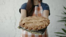 a woman holding a pie 
