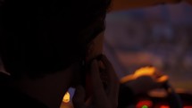 A man talking by phone during driving at night city.