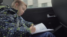 Child solving chess puzzles in the car