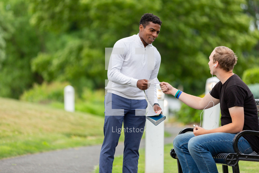 Young man handing out a gospel tract