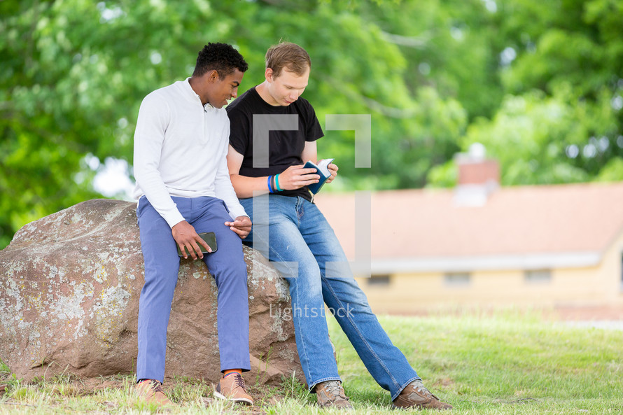 Two guys reading the Bible in the park