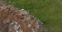 Aerial shot Environmental Pollution - Plastic Bottles, Bags And Trash In Green Field.