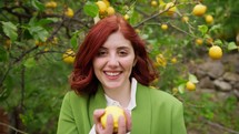 Woman smiling at the camera holding a lemon.