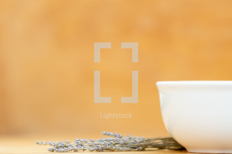 white bowl with lavender on light wood background