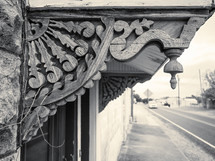 weathered gingerbread trim in black and white with soft-focus small town street