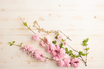 Rosary with pink flowers on a white background