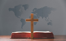 Cross and Bible in front of a map of the world