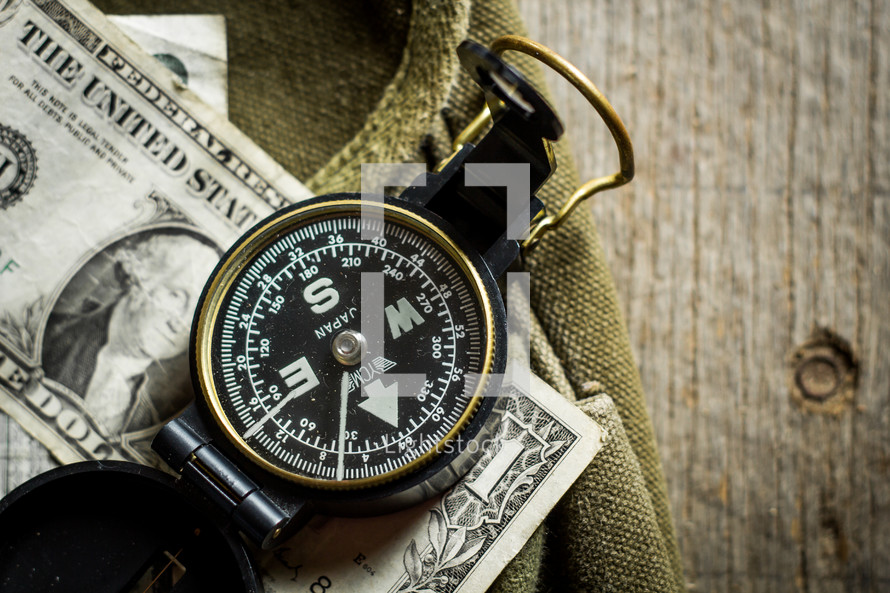 compass and cash on a green bag 