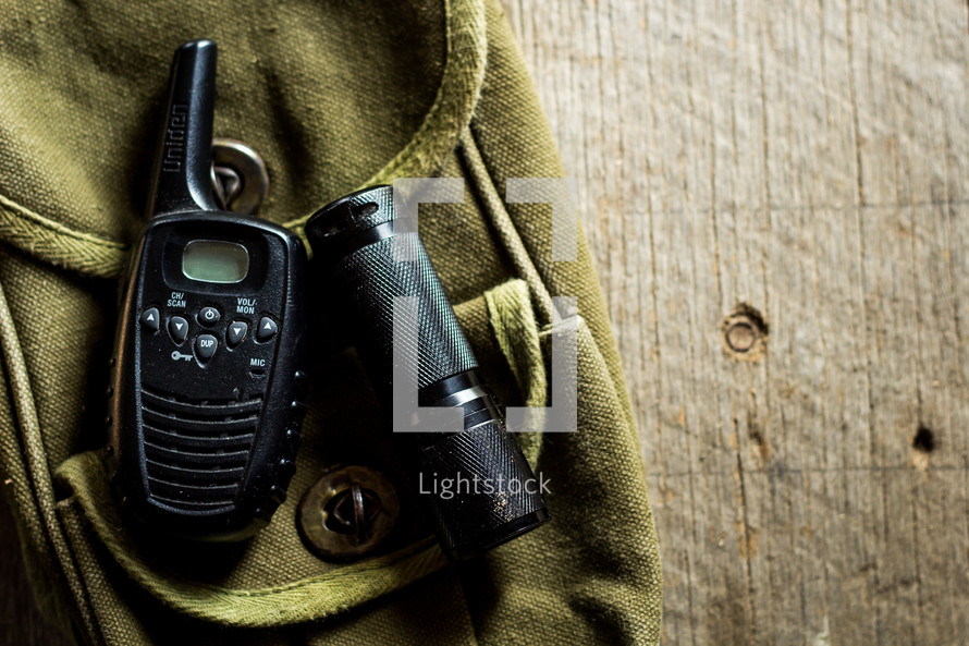 flashlight and hand-held radio on a green bag 