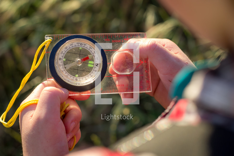 a child looking at a compass 