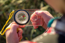a child looking at a compass 