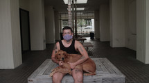 a person wearing a face mask with his dog 