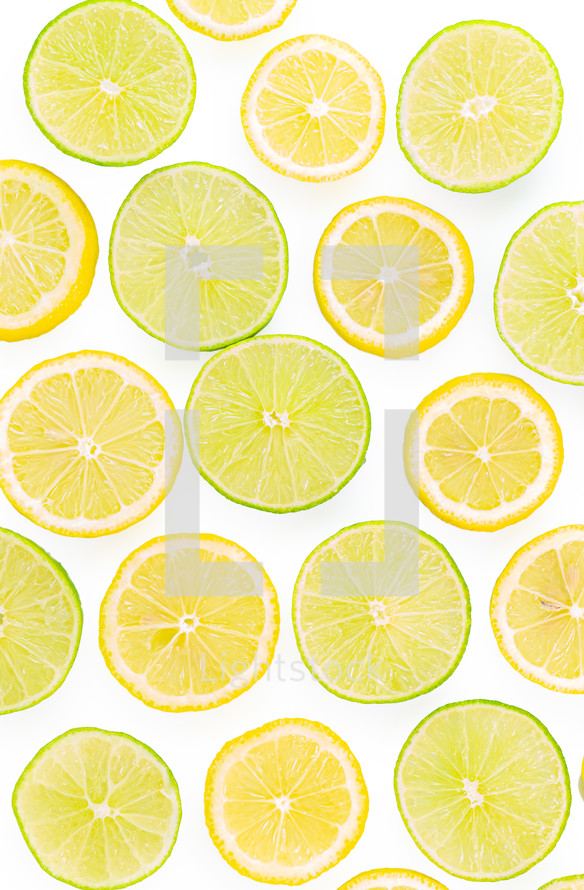 Sliced limes and lemons against a white background