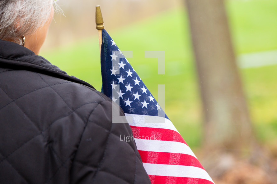 Close up behind woman holding american flag