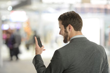 Young businessman on the cell phone inside an airport with blury background