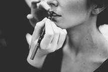 woman putting on lip liner 
