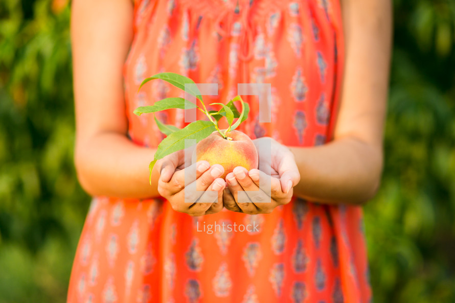 woman holding a peach 