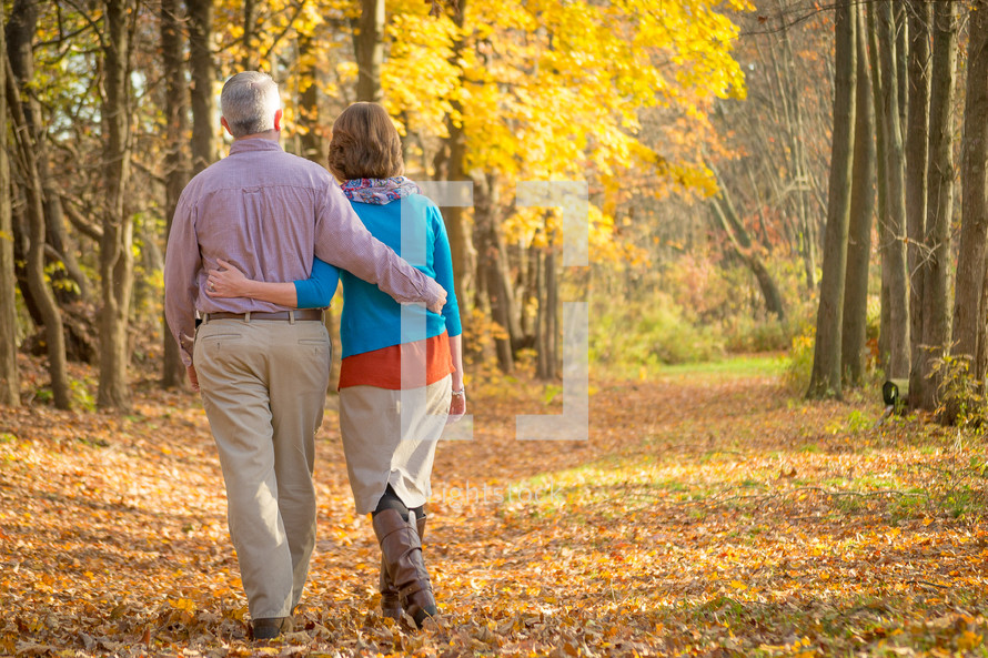 couple walking through a forest in fall 