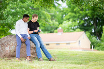 Two men outdoors reading the Bible