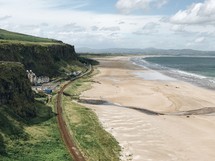 cliffs along a shoreline and tide washing onto a beach 