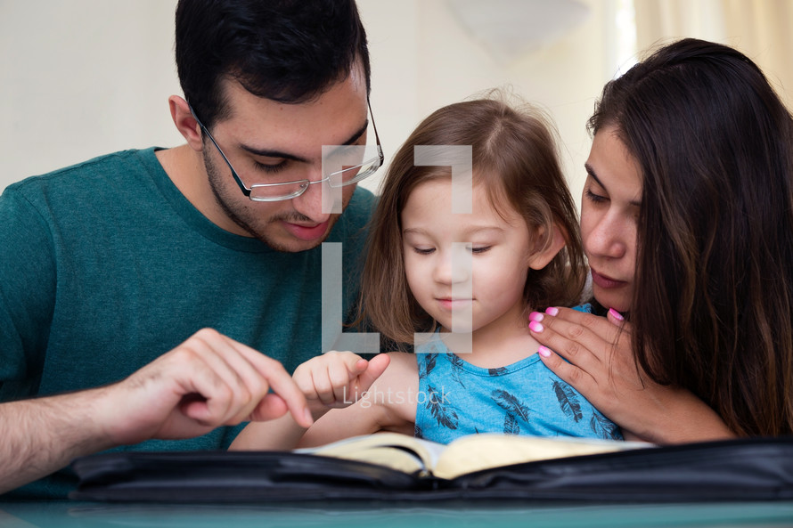 Family Studying Bible With Child 