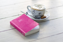 Women's Bible and coffee on a wood table 