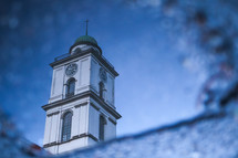 view of a church steeple through an icy window 