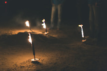 Burning torches in the ground.