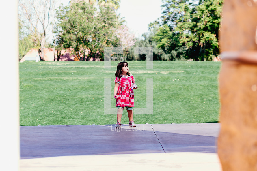 a little girl standing outdoors 