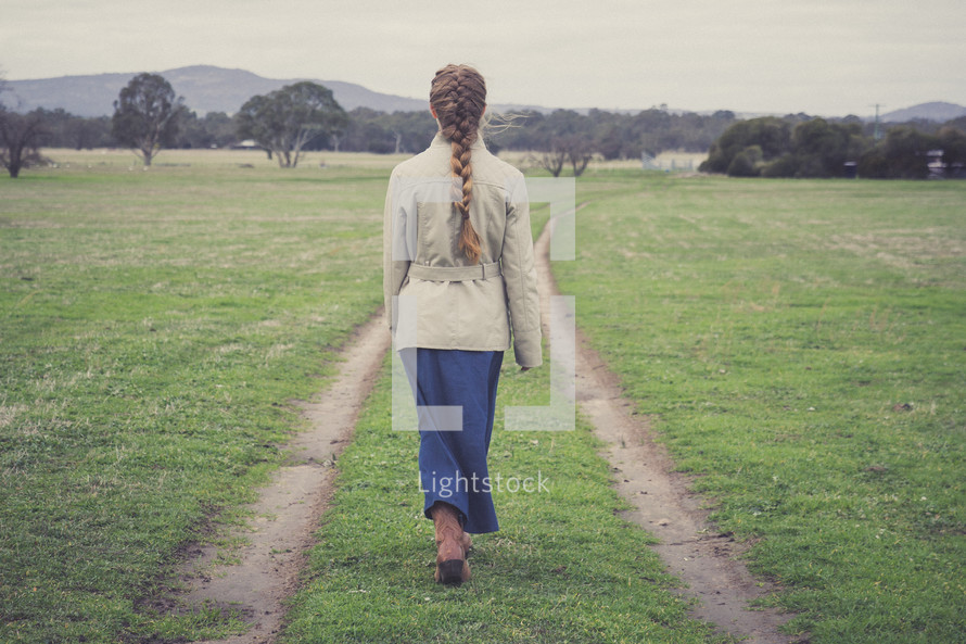 a girl walking on a worn path 
