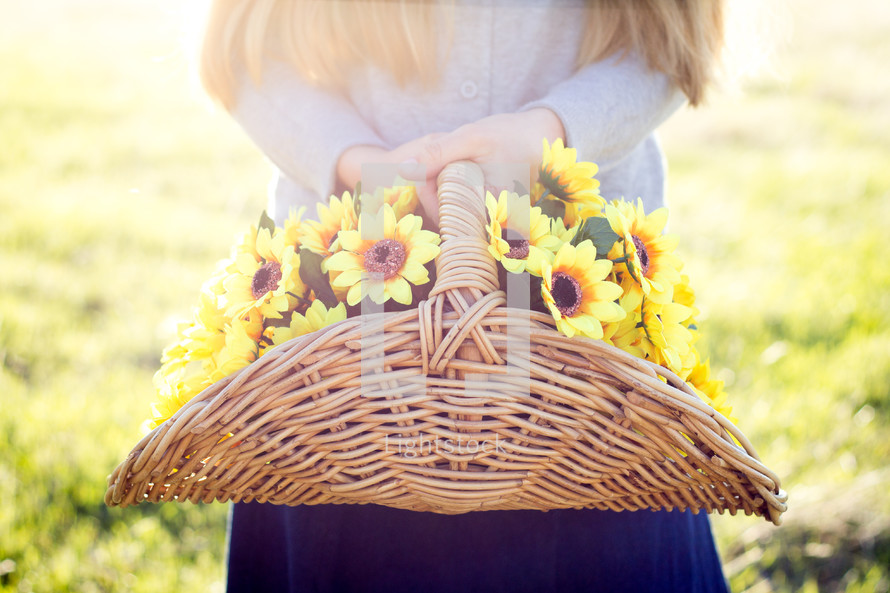 Girl holding basket of Yellow Flowers