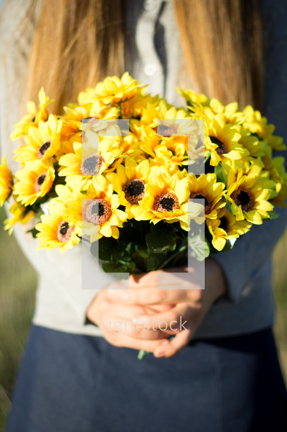 Girl Holding bunch of yellow flowers