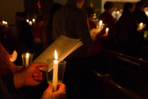 people in a congregation at a Christmas Eve candlelight service