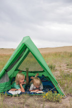 children reading Bibles in a tent
