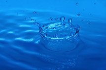 Water dripping into a pool of water forming a crown.