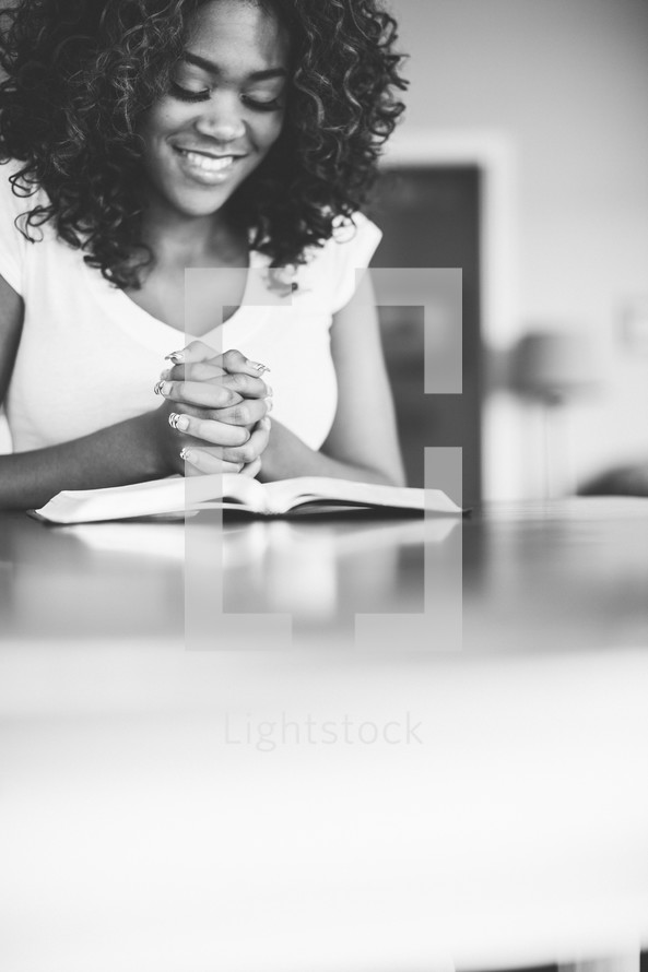 woman in prayer over a Bible