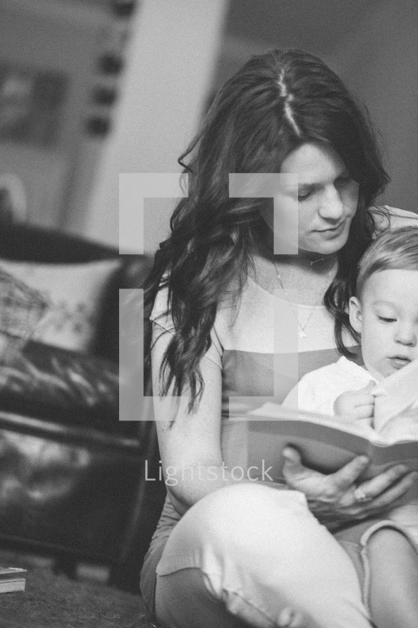 mother reading a Bible with her toddler son