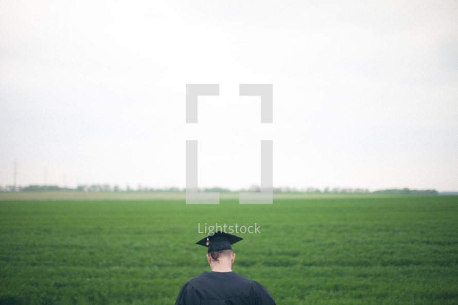 Graduate in a field of green grass.