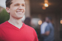 man smiling at an outdoor gathering