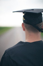 Graduate standing in the middle of the road.